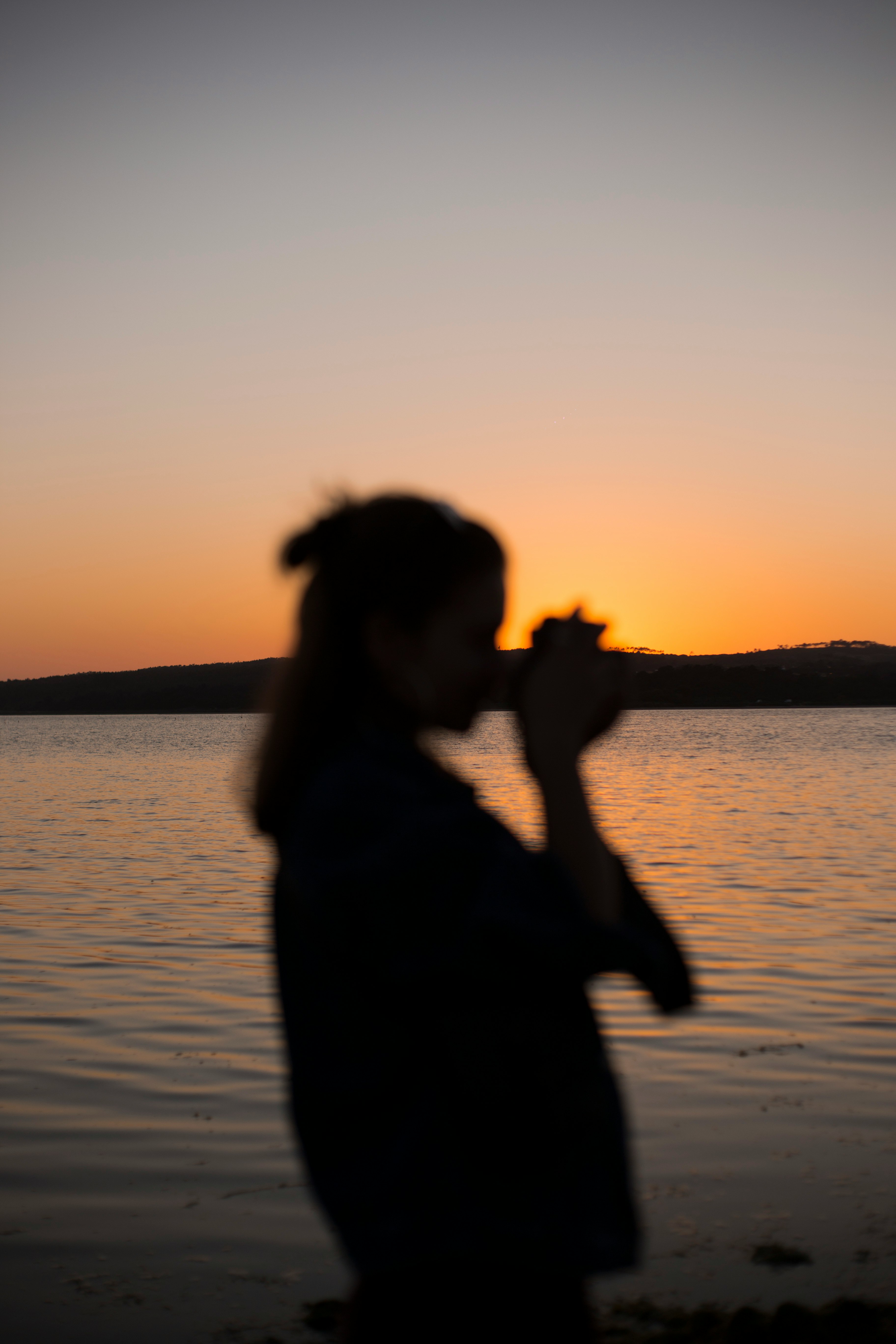 silhouette of woman near body of water